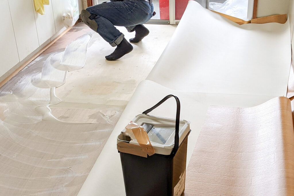 長尺シートを貼り付ける作業員