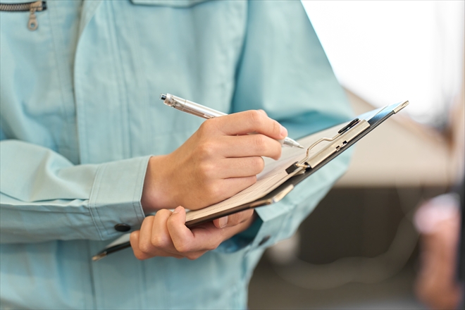 ヒアリング内容をメモする作業員