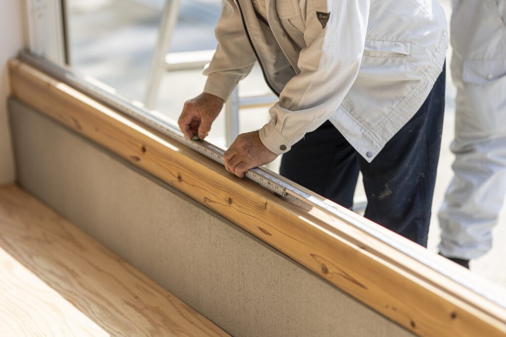 木材をメジャーで測る作業員